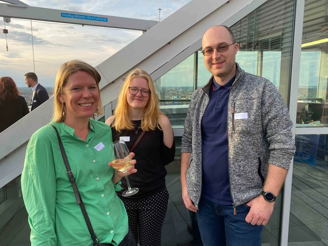 3 Personen stehen auf einer Dachterrasse