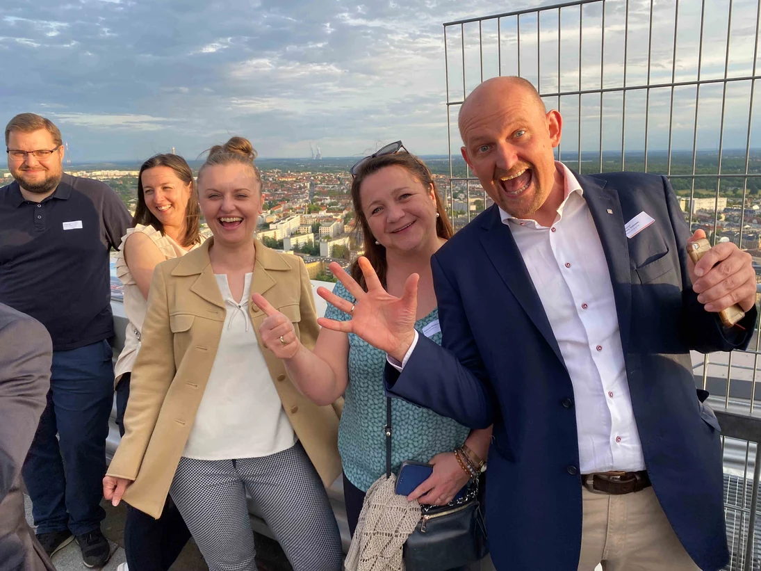 Personen stehen auf einer Dachterrasse mit Blick über Leipzig