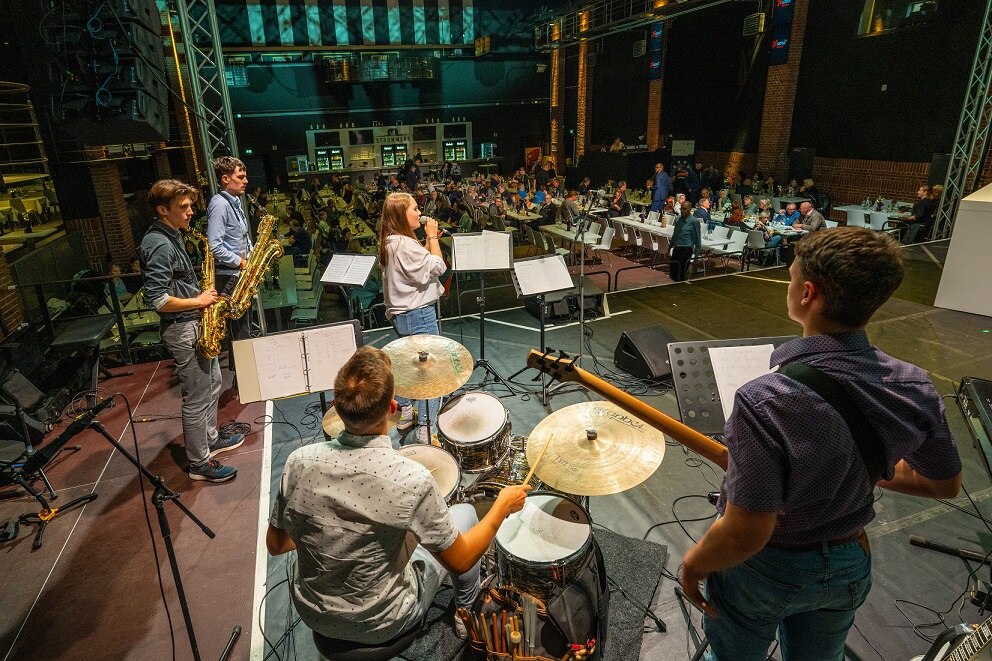 Eine Band steht auf der Bühne und musiziert.