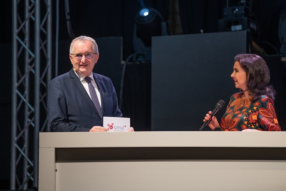 Staatsminister Schmidt unterhält sich an einem Tisch mit der Moderatorin