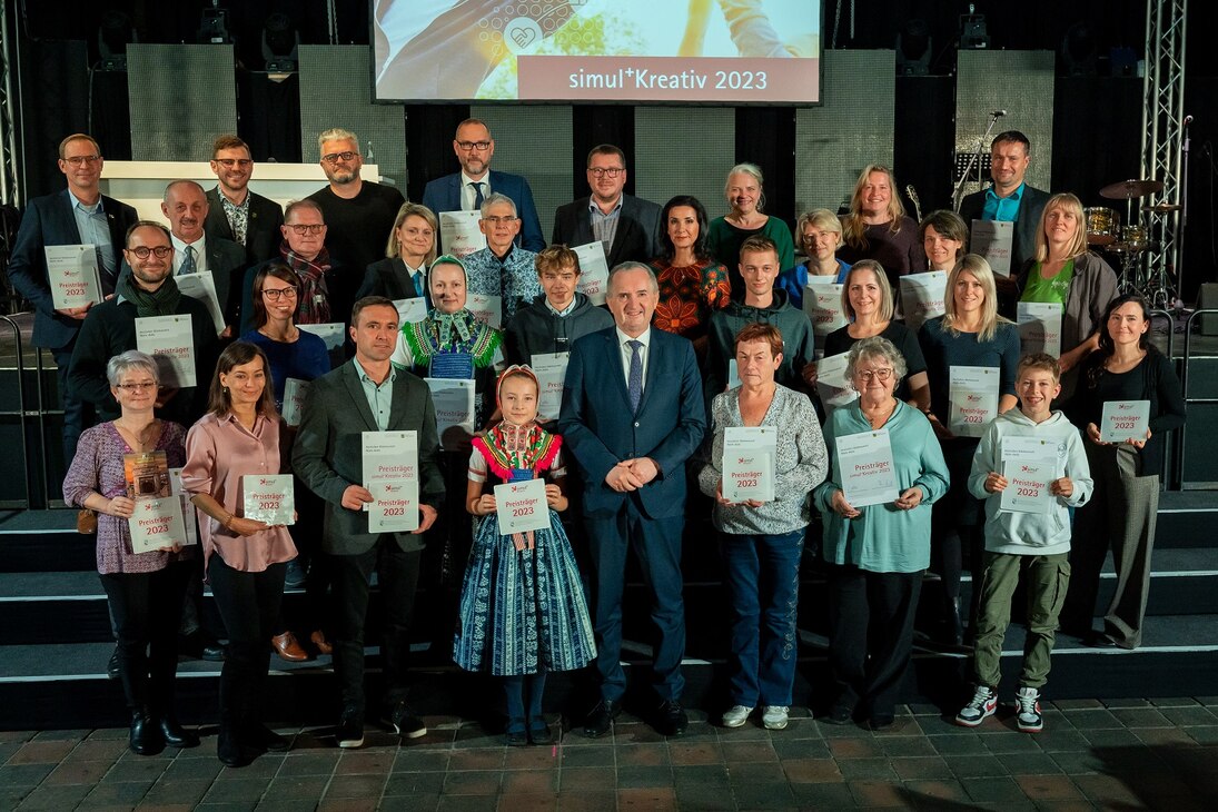 Staatsminister Schmidt steht in einer großen Gruppe von Preisträgern