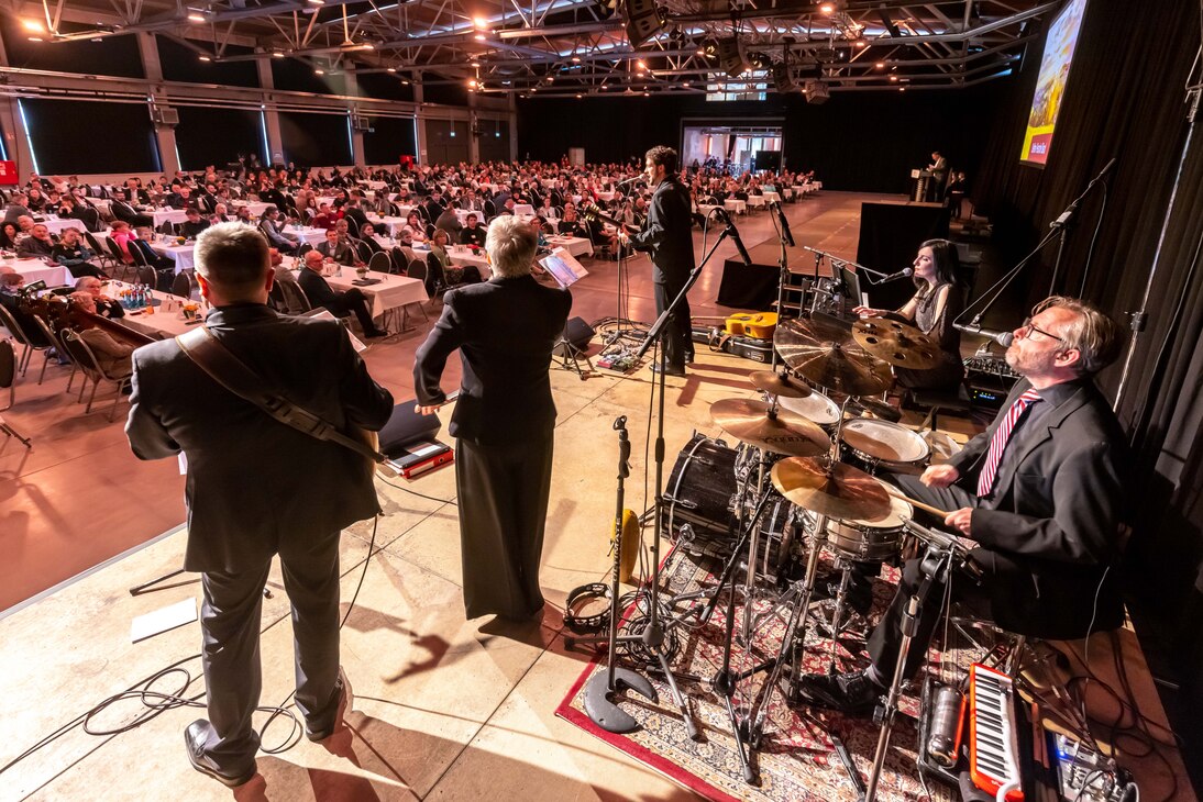 Eine Band spielt auf einer Bühne vor dem Publikum