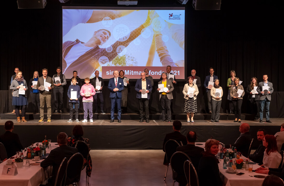 Gruppe von Preisträgern mit Staatsminister Thomas Schmidt auf der Bühne