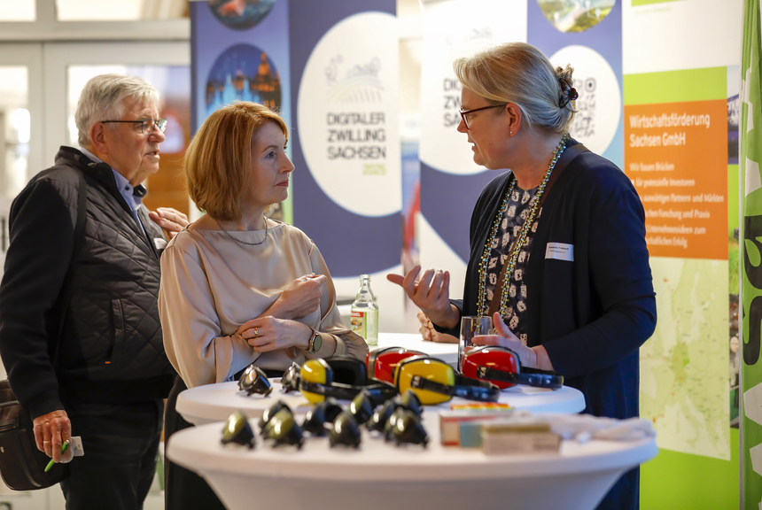 Zwei Frauen stehen an einem Tisch und unterhalten sich.