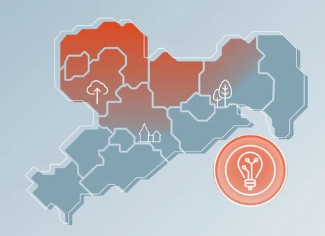 Eine blau-orange Karte mit kleinen Piktogrammen des Freistaates Sachsen vor hellblauem Hintergrund. Am rechten unteren Bildrand ist ein oranges Piktogramm einer Glühbirne hinterlegt.